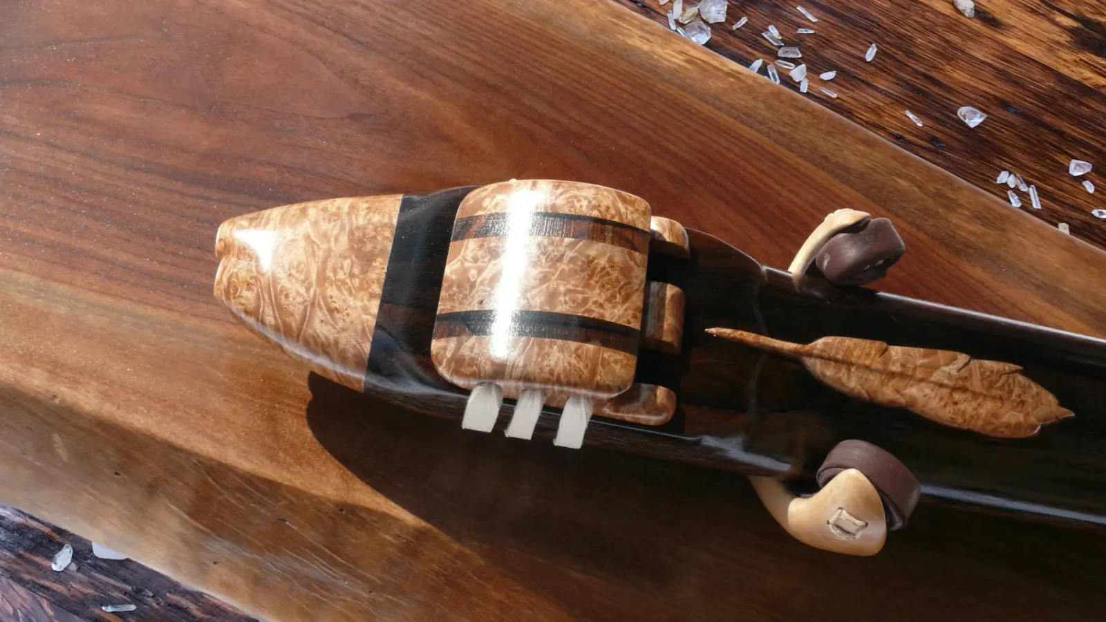 Hand-carved feather detail on a bird's eye maple flute headjoint